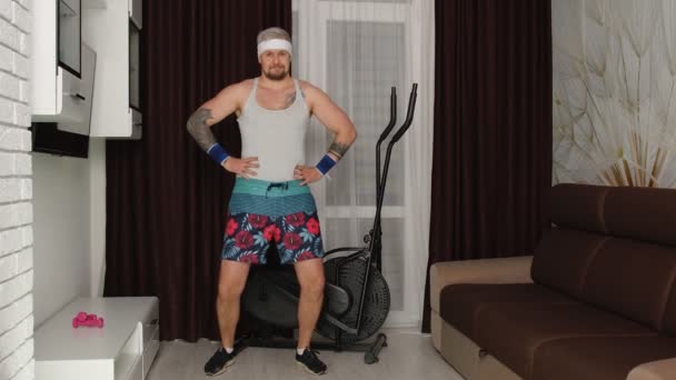 Homme drôle athlète sportif avec barbe fait des exercices d'étirement d'entraînement, pratiquer le sport à la maison — Video