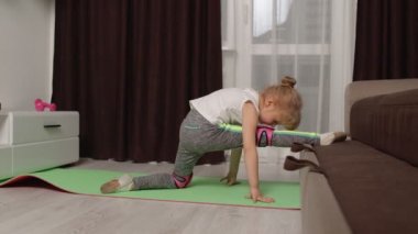 Çocuk evde jimnastik eğitimi sicim esnetiyor, çocuklar spor egzersizleri yapıyor.