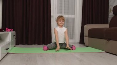 Çocuk çocuk jimnastik yapıyor evde egzersiz yapıyor, video dersleri veriyor.