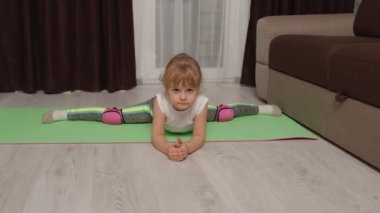 Çocuk evde jimnastik eğitimi sicim esnetiyor, çocuklar spor egzersizleri yapıyor.