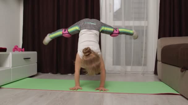 Kind trainiert Gymnastik Stretching Zwirn zu Hause, Kinder Mädchen machen Sport Workout-Übungen — Stockvideo