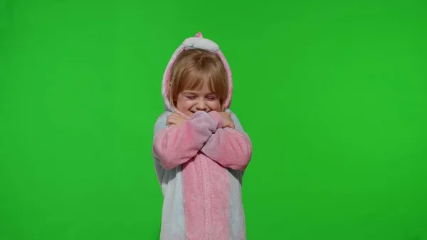 Menina criança loira sorrindo, abraçando, abraçando em traje de pijama de unicórnio na tecla chroma — Fotografia de Stock