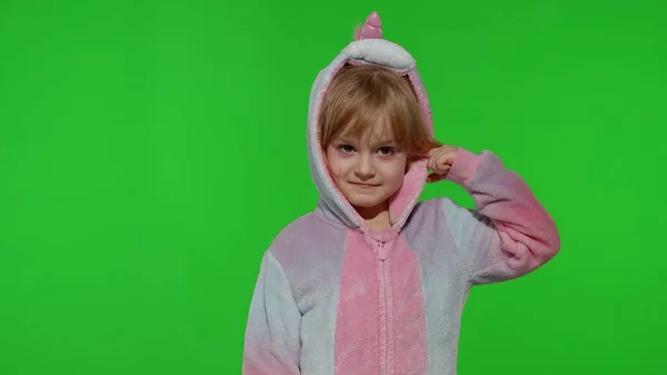 Little blonde child girl smiling, dancing, celebrating in unicorn pajamas costume on chroma key — Stock Photo, Image