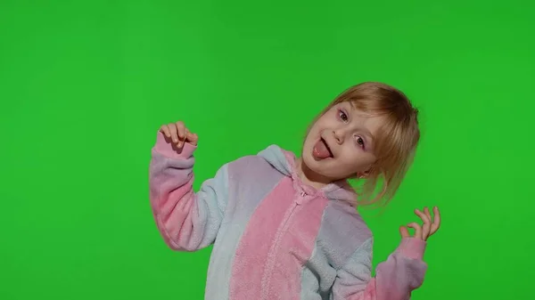 Menina criança em pijama unicórnio fazendo caras engraçadas bobas, brincando, dançando na tecla chroma — Fotografia de Stock