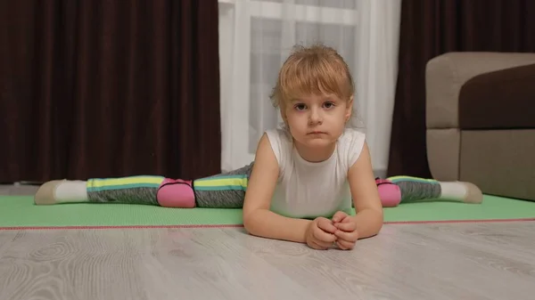Kind kind training gymnastiek stretching twine thuis, kinderen meisje maken sport workout oefeningen — Stockfoto