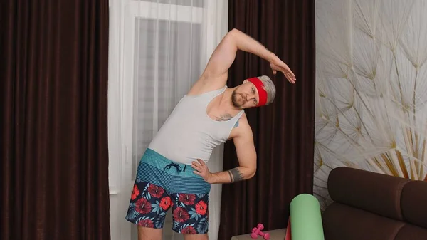 Funny man Athlet Sportler mit Bart macht Workout Dehnübungen, Sport zu Hause — Stockfoto