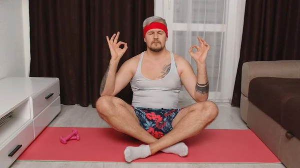 Retro man model man kalmeert, het beoefenen van yoga mediteren thuis zitten in ontspannen lotus pose — Stockfoto