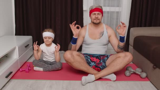 Gyerek lánya és fiatal apja retro stílusú ruházat csinál jóga meditációs gyakorlatok együtt — Stock videók
