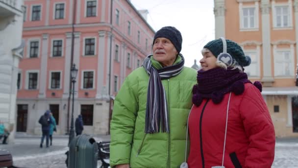 Stylový šťastný senior pár turisté babička dědeček chůzi, cestování v centru města Witer — Stock video