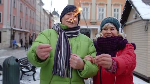 Couple aîné avec des étincelles brûlantes bengale lumières célébrant anniversaire sur la rue du centre-ville — Video