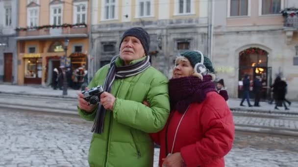 Dziadek robiący zdjęcia z babcią na kamerze retro w zimowym śnieżnym miasteczku Lwów Ukraina — Wideo stockowe