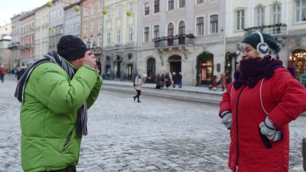 Старша пара туристів бабуся робить фотографії на ретро-камеру в зимовому місті — стокове відео