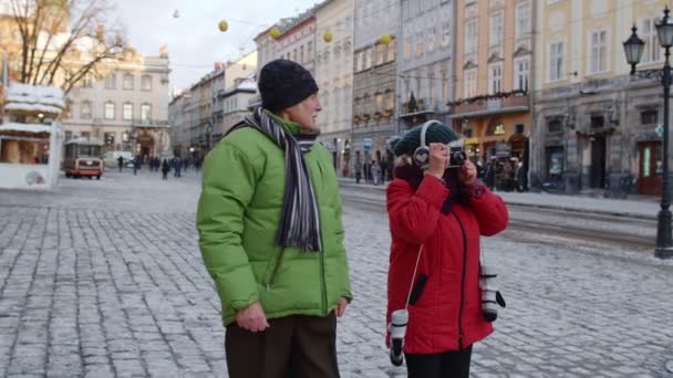 Starsza para turystów babcia dziadek robi zdjęcia na retro aparat fotograficzny w zimowym mieście — Wideo stockowe