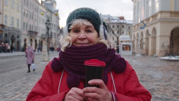 Porträtt av senior kvinna turist leende, tittar på kameran i vinter centrum av Lviv, Ukraina — Stockvideo