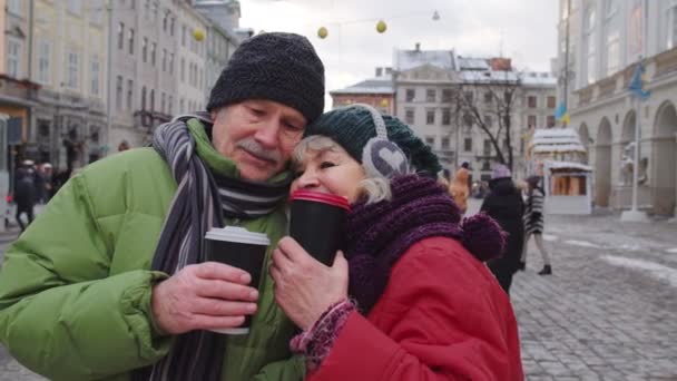 Senioren vrouw echtgenoot toeristen drinken uit bekers, genieten van warme drank thee op de stad centrale straat — Stockvideo