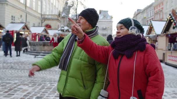 Mayores de edad pareja turistas abuela abuelo alojarse en el centro de la ciudad de invierno Lviv, Ucrania — Vídeos de Stock