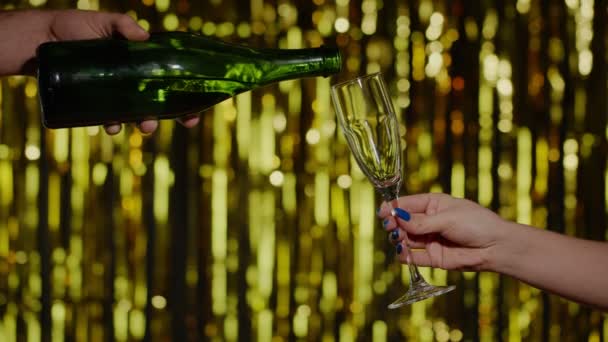 Champán bebida alcohólica se vierte de la botella en el vidrio de beber fondo de oro en cámara lenta — Vídeos de Stock