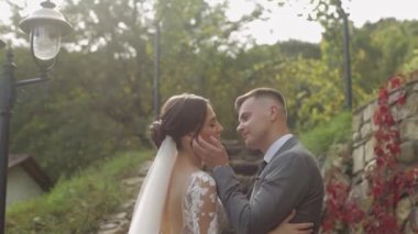 Sevgili yeni evliler, beyaz gelinler parkta damadı kucaklıyor öpüşüyor, düğün çifti sarılıyor.