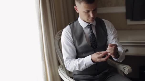 Mężczyzna w garniturze założył zegarek. Sukienki ślubne. Młody biznesmen czeka na spotkanie. — Wideo stockowe