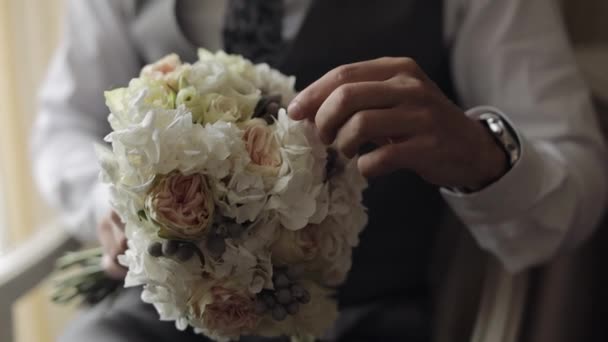 Γαμπρός με γαμήλια ανθοδέσμη στα χέρια του στο σπίτι ετοιμάζεται να πάει στη νύφη, close-up αργή κίνηση — Αρχείο Βίντεο