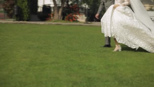 Precioso recién casados novio novia caucásica corriendo en el parque, de la mano, la familia de la pareja de boda — Vídeo de stock