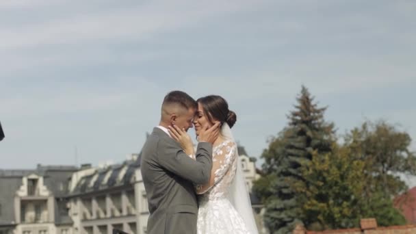 Lovely newlyweds caucasian bride embracing groom in park making kiss, wedding couple family hugging — Stock Video