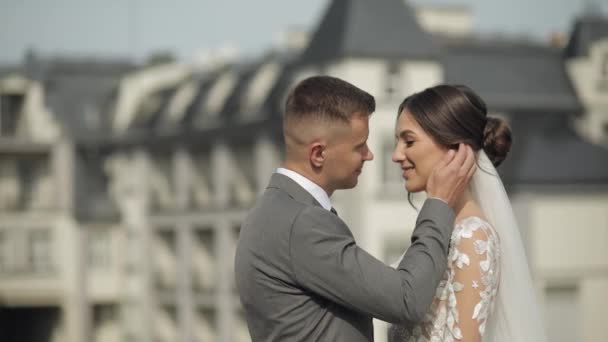 Прекрасные молодожены кавказская невеста обнимает жениха целует, свадебная пара обнимает друг друга — стоковое видео