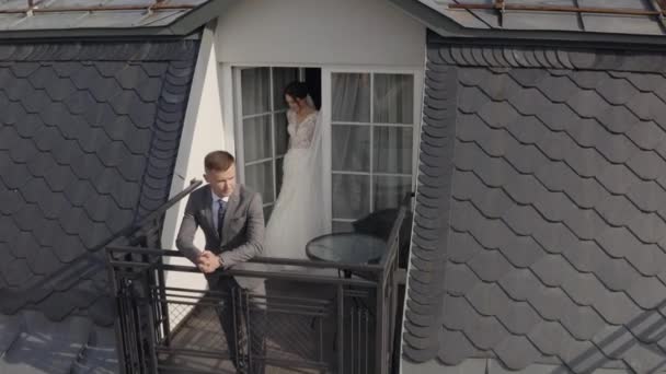 Kaukasisch pasgetrouwde bruid omhelst bruidegom op balkon in hotelkamer, vanuit de lucht — Stockvideo