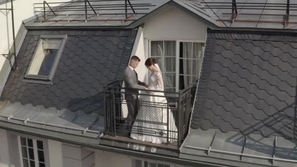 Caucazieni proaspăt căsătoriți mireasă îmbrățișând mirele pe balcon în camera de hotel, vedere aeriană — Videoclip de stoc