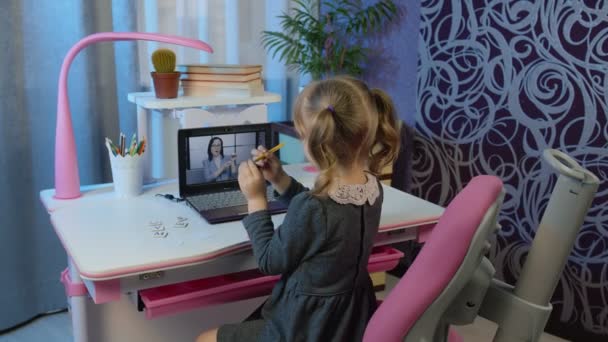 Ragazza che studia compiti a casa con insegnante donna sul computer portatile durante le lezioni online a casa — Video Stock