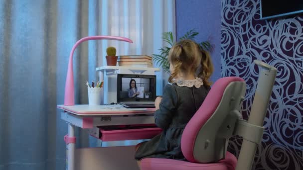 Niña haciendo la tarea de la escuela en el ordenador portátil en casa con la maestra, la educación a distancia — Vídeo de stock