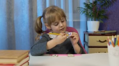 Çocuk ev ödevi yaparken video görüşmesi yapıyor, uzaktan eğitim alıyor.