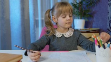Çocuk ev ödevi yaparken video görüşmesi yapıyor, uzaktan eğitim alıyor.