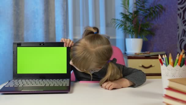 Дитяча дівчина з ноутбуком, дивлячись на зелений екран вдома, уроки онлайн дистанції для дітей — стокове відео
