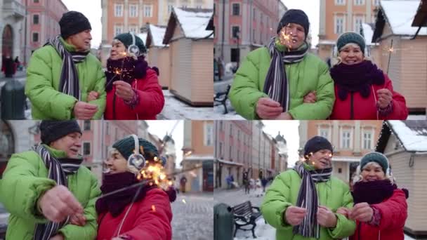 Multi-screen shot pareja de ancianos celebración de luces de bengala chispas disfrutando de la Navidad en la calle de la ciudad — Vídeo de stock