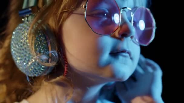 Elégant enfant branché dans les lunettes de soleil à disco party cyberpunk club regardant la caméra et souriant — Video