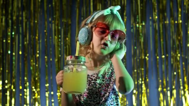 Chica adolescente hipster futurista con jugo de piña escuchando música en auriculares, bailando — Vídeo de stock