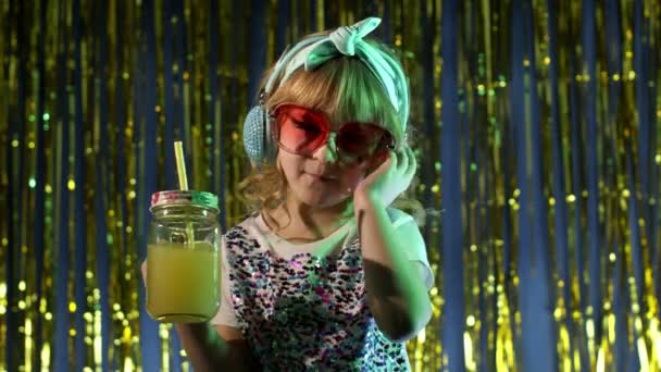 파인애플 주스 를 손에 들고 헤드폰 으로 음악을 듣고 춤을 추는 장래성 있는 10 대 소녀 — 비디오