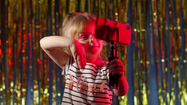 Chica de moda en club nocturno futurista con luces de neón rojas haciendo selfie de videollamada en el teléfono móvil — Vídeo de stock