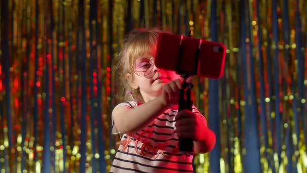 Grazioso bambino blogger registrazione video blog vlog sul telefono cellulare, facendo foto selfie nel night club — Video Stock