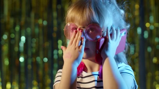 미래의 안경을 쓴 소녀가 네온 블루 라이트를 켜고 나이트 클럽에서 친구와 휴대폰으로 이야기하는 모습 — 비디오