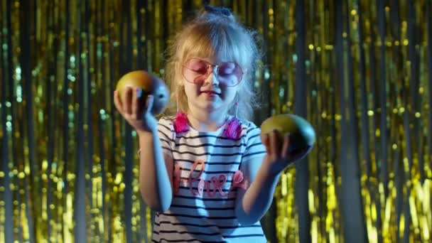 Stílusos aranyos tini gyerek lány mangó gyümölcsök álló fényes háttér tánc bolondozás körül — Stock videók
