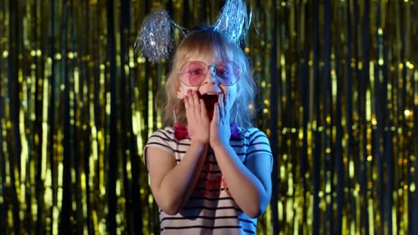 Trendy girl raising hands in surprise looking at camera with big eyes, shocked by victory, say wow — Stock Video