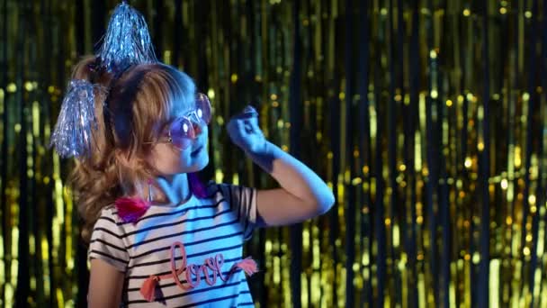 Gadis remaja bergaya yang berdiri di lampu neon biru menyala dan titik-titik pada ruang kosong, tanda setuju — Stok Video