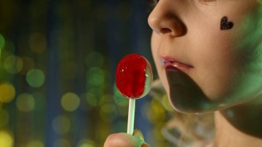Close-up shot of stylish teenager caucasian kid girl lips licking lollipop with tongue clipart