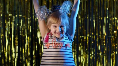 Sevimli küçük kız başarının tadını çıkarıyor, zaferi kutluyor, zaferi kutluyor, gece kulübünde motive oluyor.