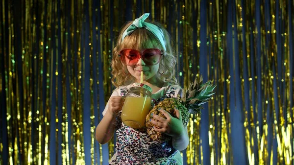 Bambino alla moda con succo di frutta all'ananas nel club futuristico con luce al neon — Foto Stock