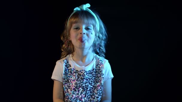 Portret van trendy stijlvolle meisje tonen tong, rommelen rond in neon licht in disco party studio — Stockvideo