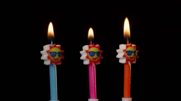 Narozeniny slavnostní svíčky v podobě slunce ve slunečních brýlích soustružení, točení izolované na černém pozadí — Stock video