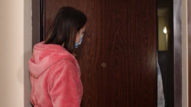 Yazılı metni olan doktor, Coronavirus 'a karşı aşı önererek evdeki kadını ziyaret ediyor.